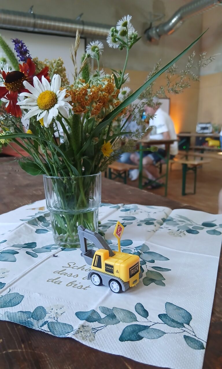 Kleine Bagger und frische Blumen erinnerten auf den Tischen an den gemeinsamen Weg von der Baustelle zum Ort der Nachsorge.